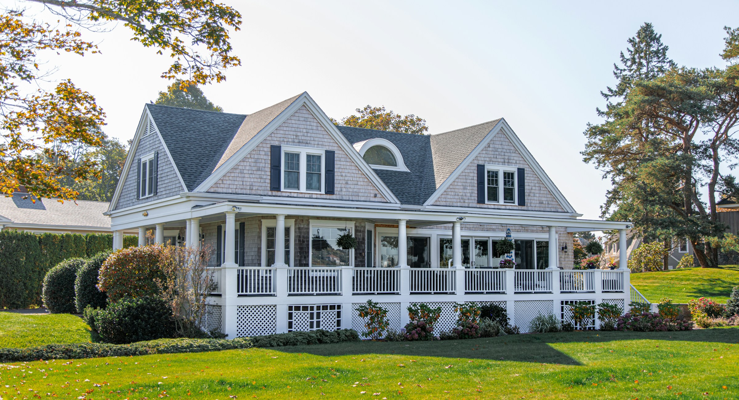 A white house with a covered front porch on a sunny afternoon
